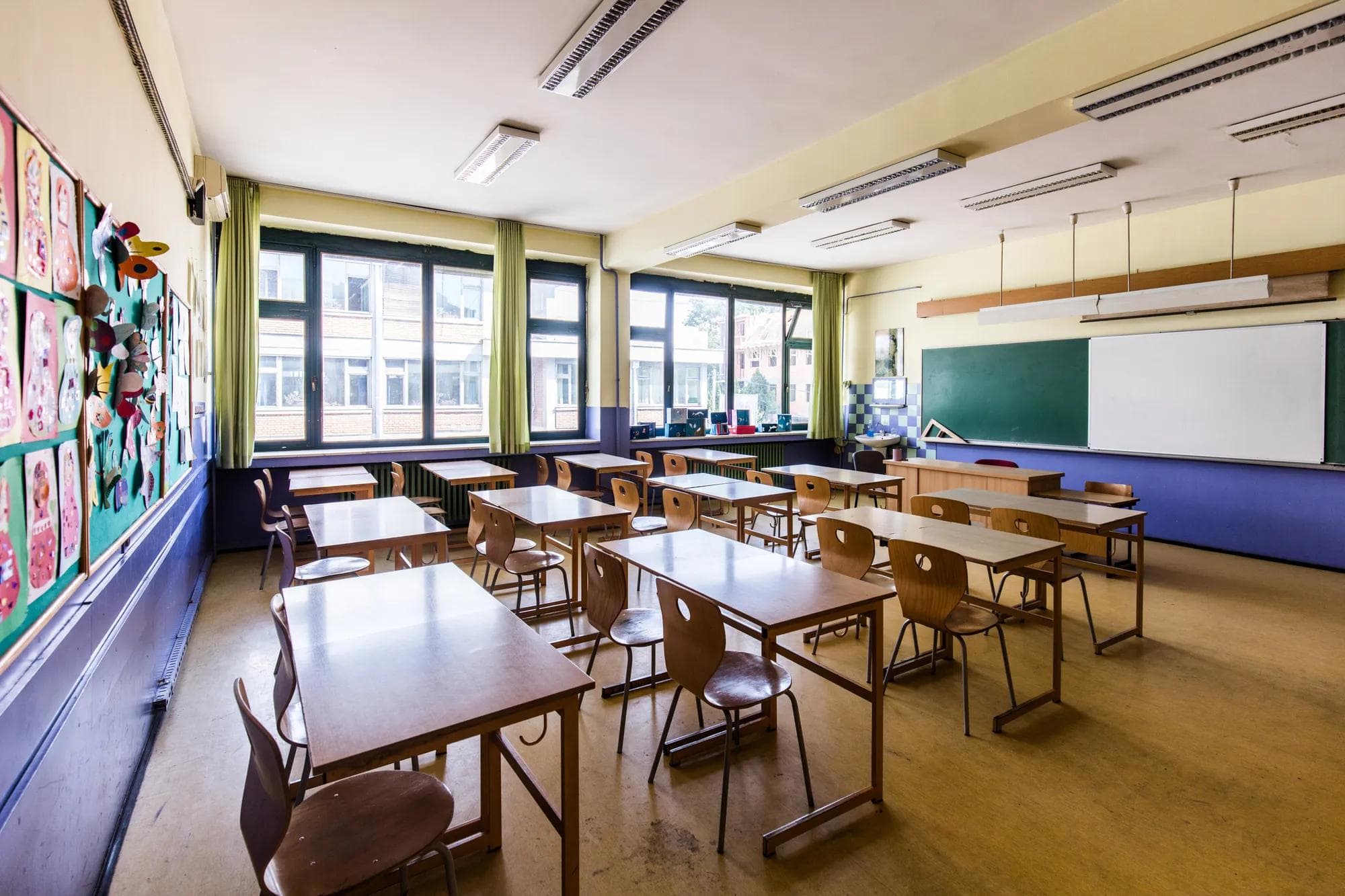Empty elementary classroom with light shining through windows