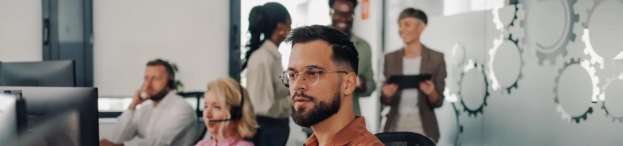 Male operator wearing glasses concentrates on his computer