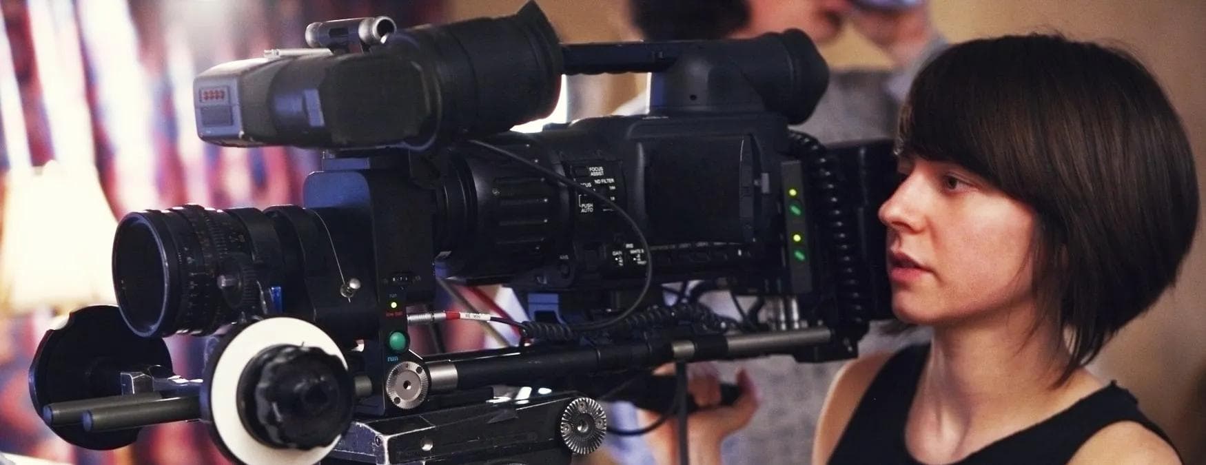 A young woman operating a camera on a video shoot 