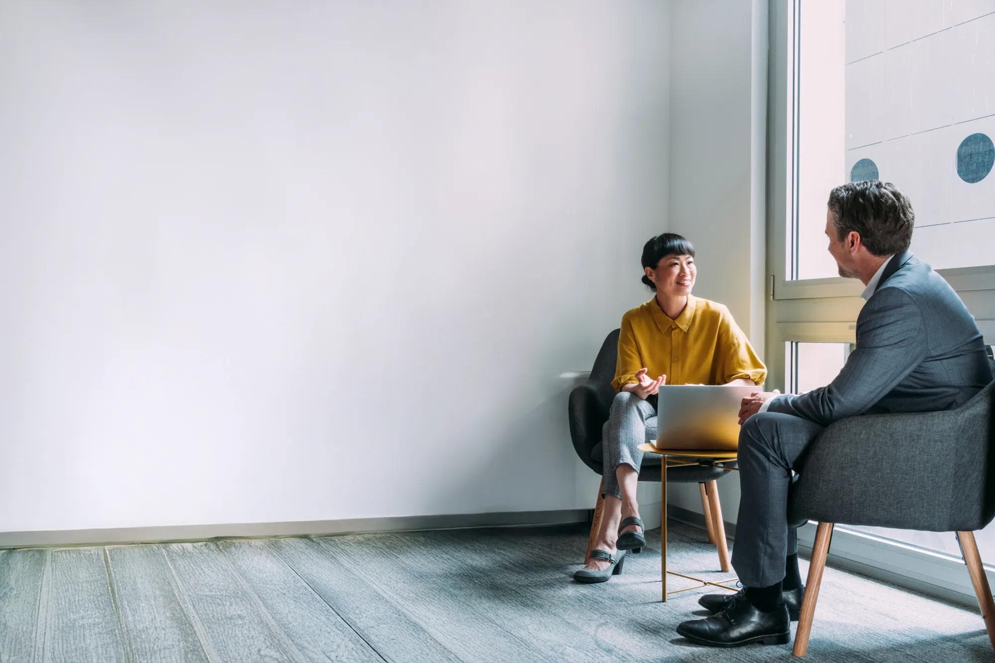 Two coworkers conversing at the office 