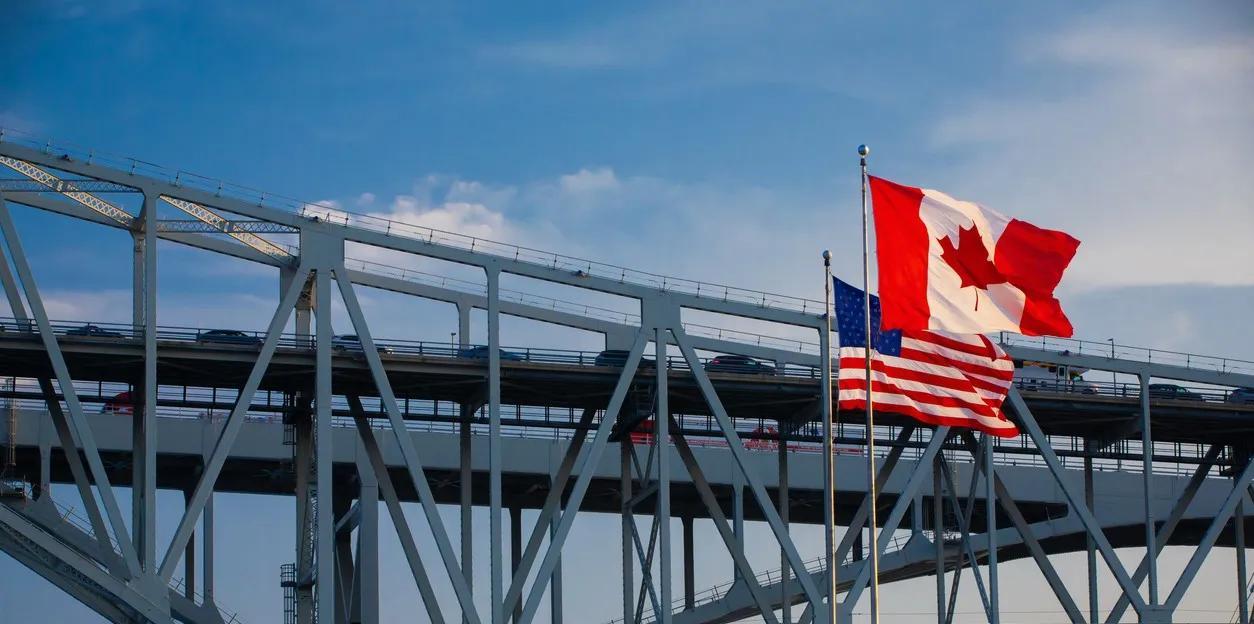 View of the Blue Water Bridge in Port Huron, Michigan with the U.S. and Canadian flags in the foreground.