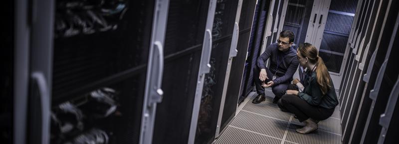 A technician explains server functioning in a data center room. 