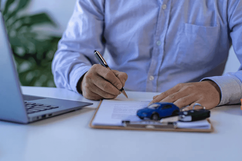 Dealer giving keys to new car owner at auto dealership