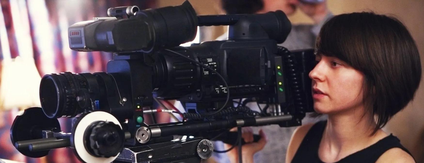 A young woman operating a camera on a video shoot 