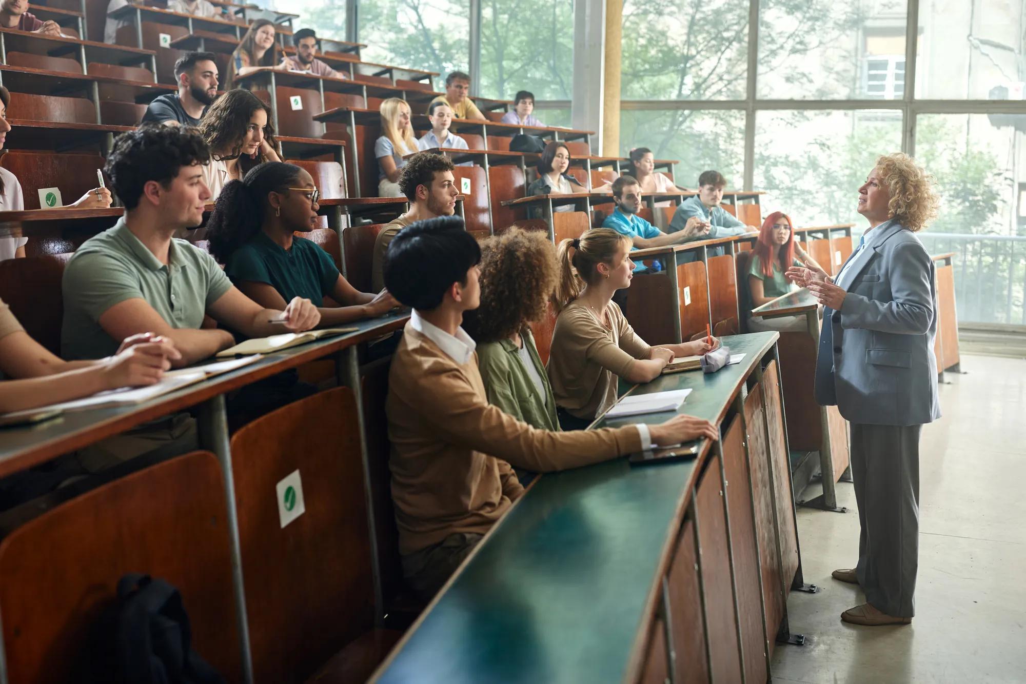 Crowd of students listening to their professor in amphitheater