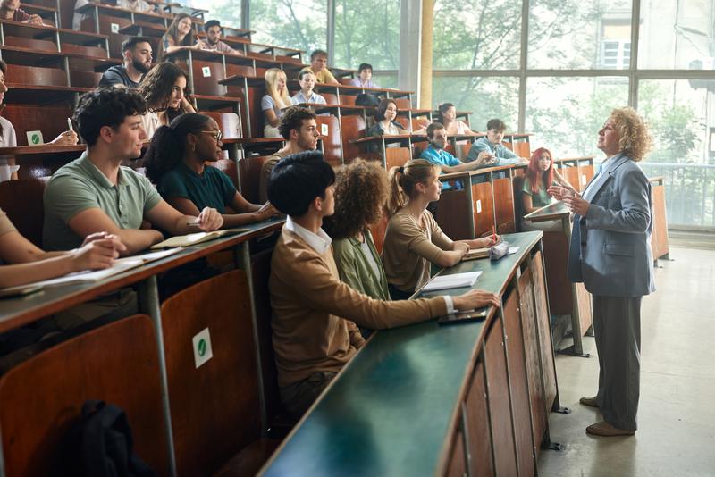 Crowd of students listening to their professor in amphitheater