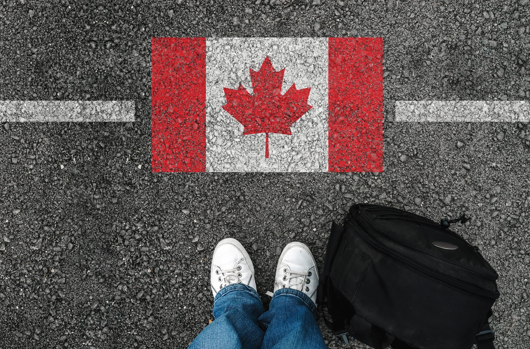 standing next to flag of Canada