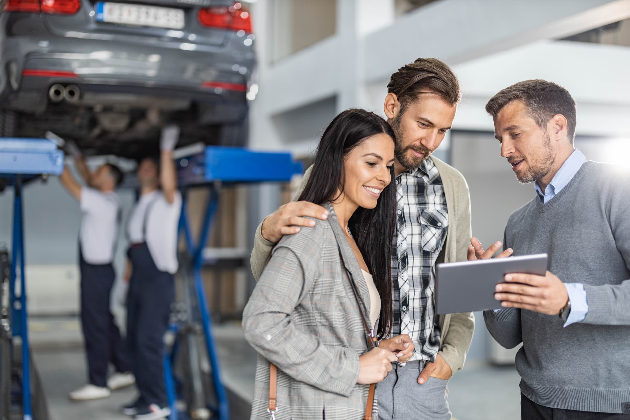 Auto service manager helping customers with their car