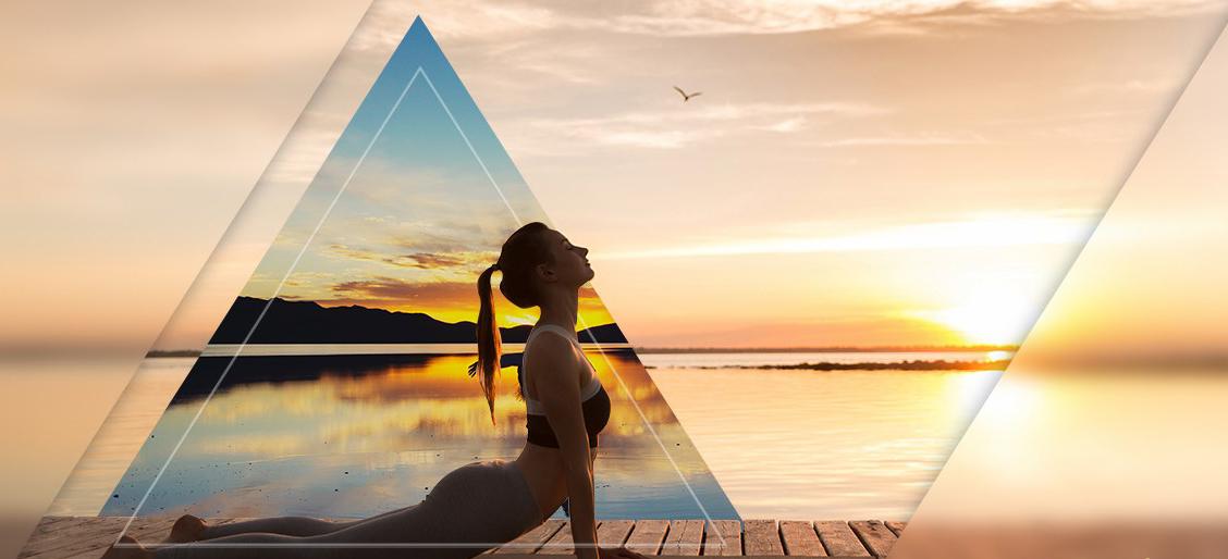 woman in yoga pose overlooking a lake at sunrise