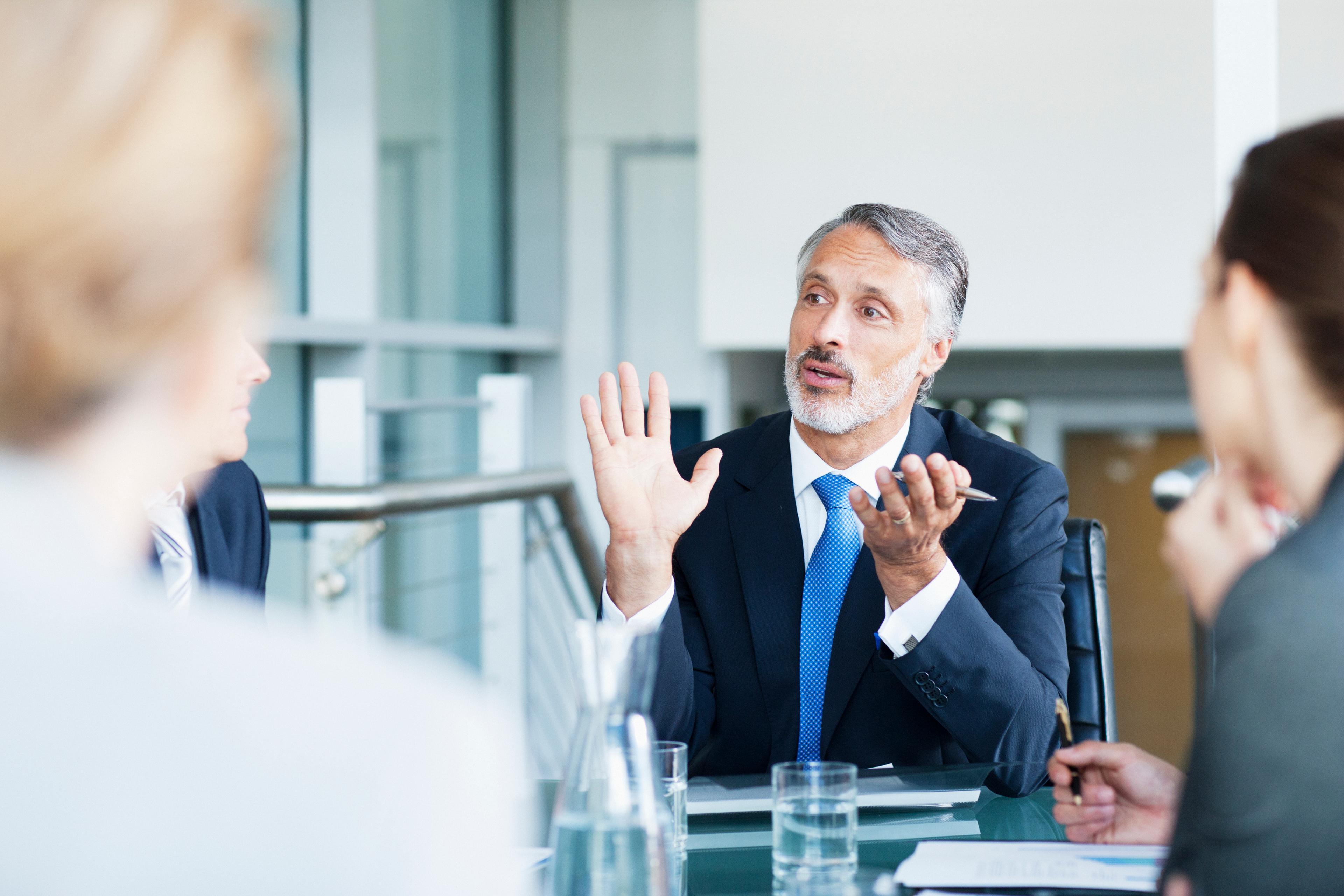 Gesturing businessman leading meeting in conference room