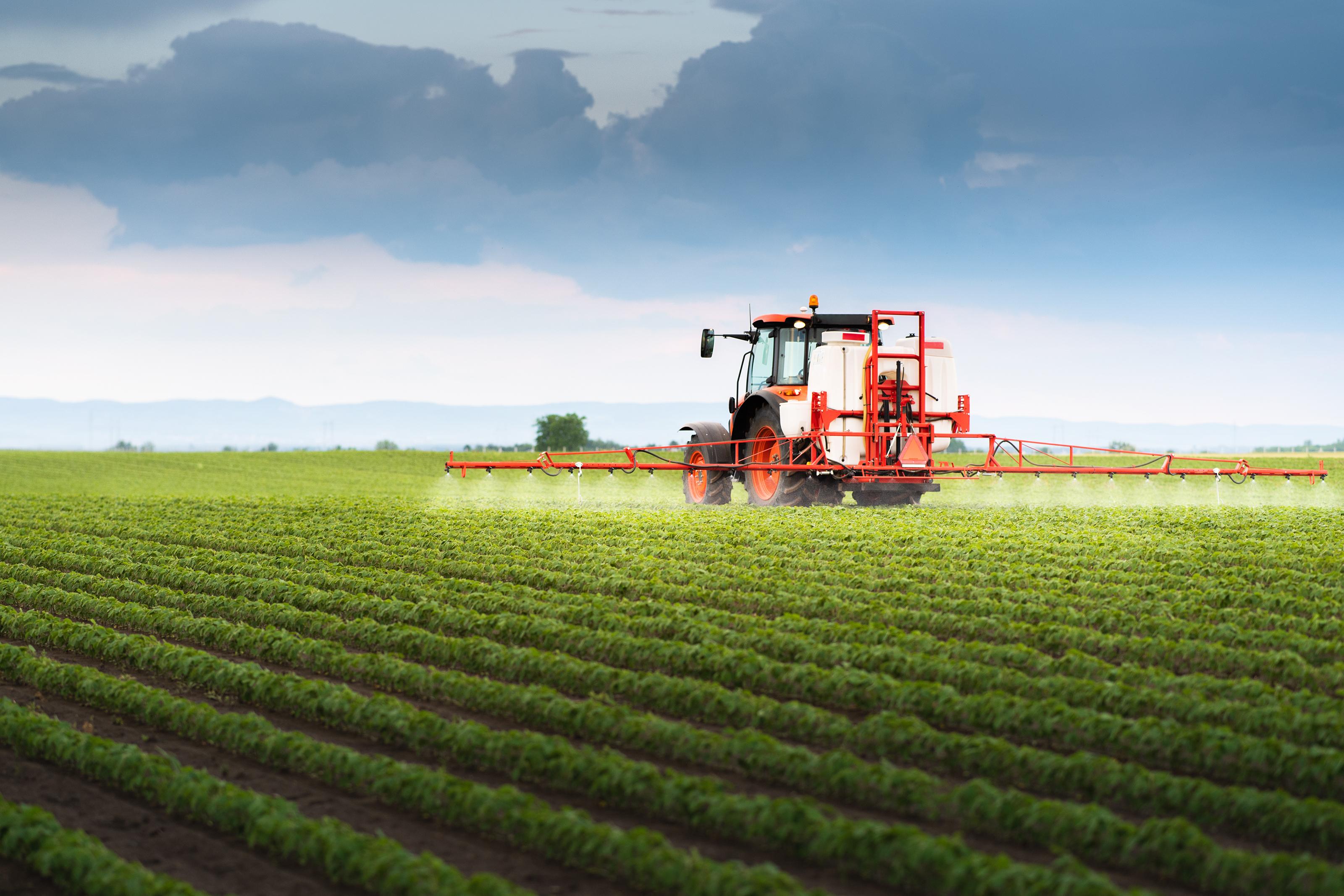 Tractor spraying soy in field
