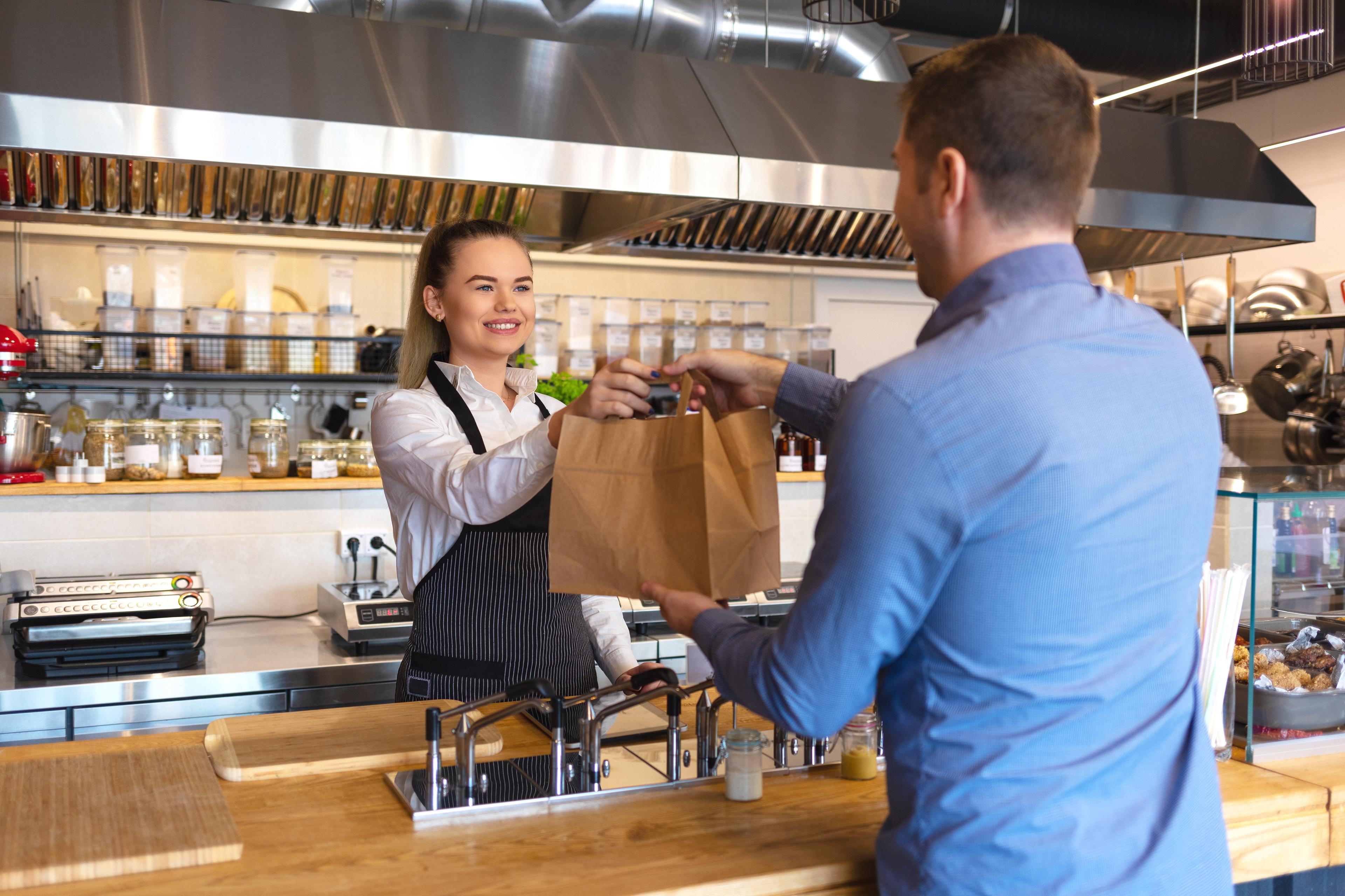 man picking up takeout from a restaurant