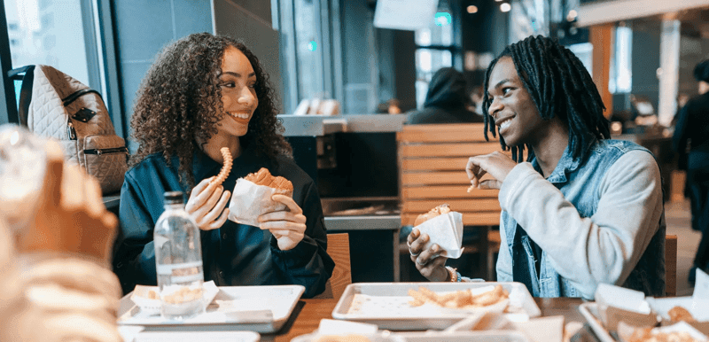 Group of young adults dine out at a fast food restaurant