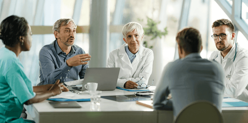 Group of doctors and businessmen talking on a meeting at doctor's office. stock photo