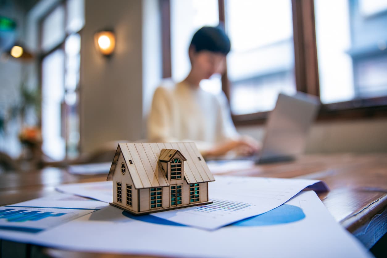 Woman working on taxes behind toy house