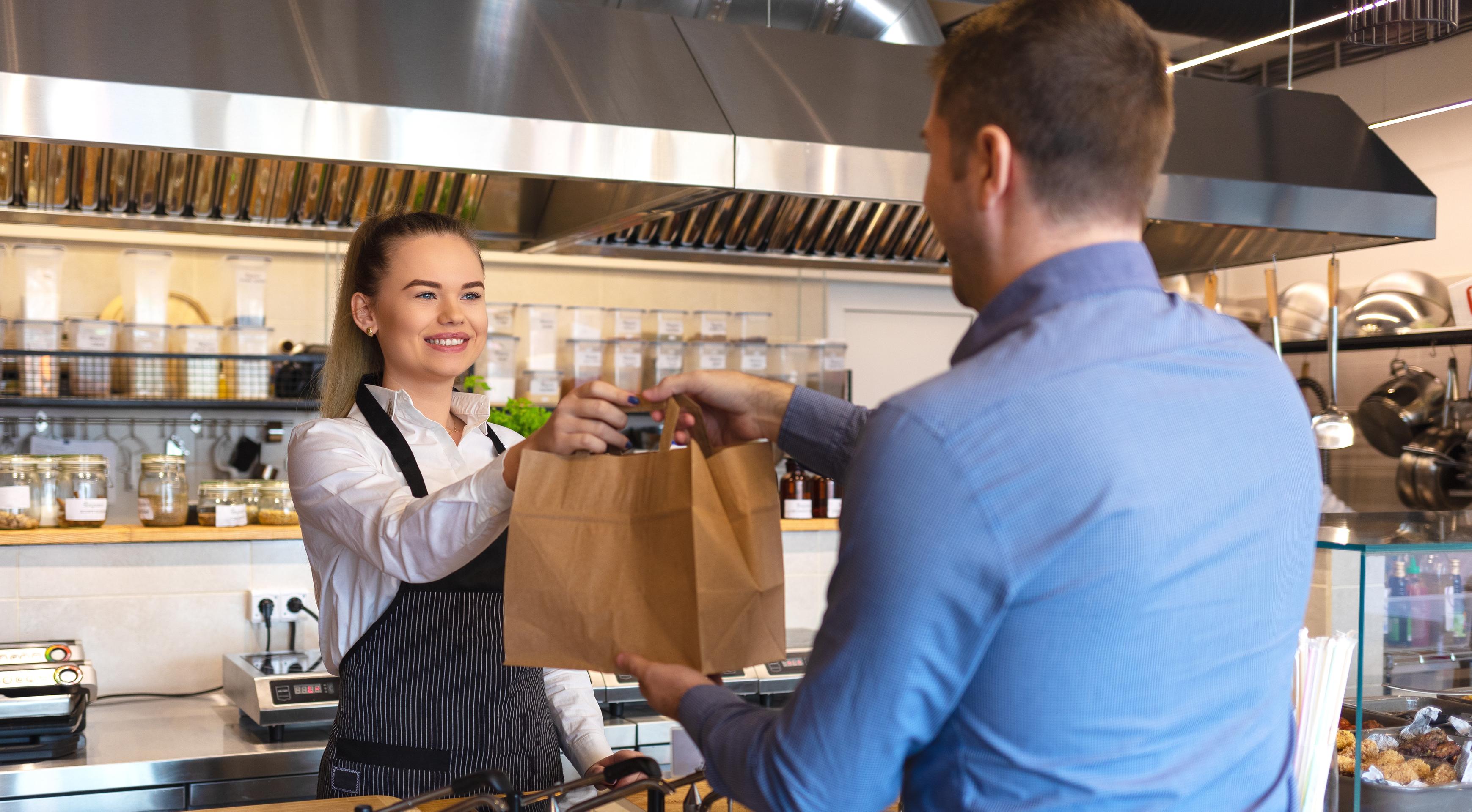 man picking up takeout from a restaurant.