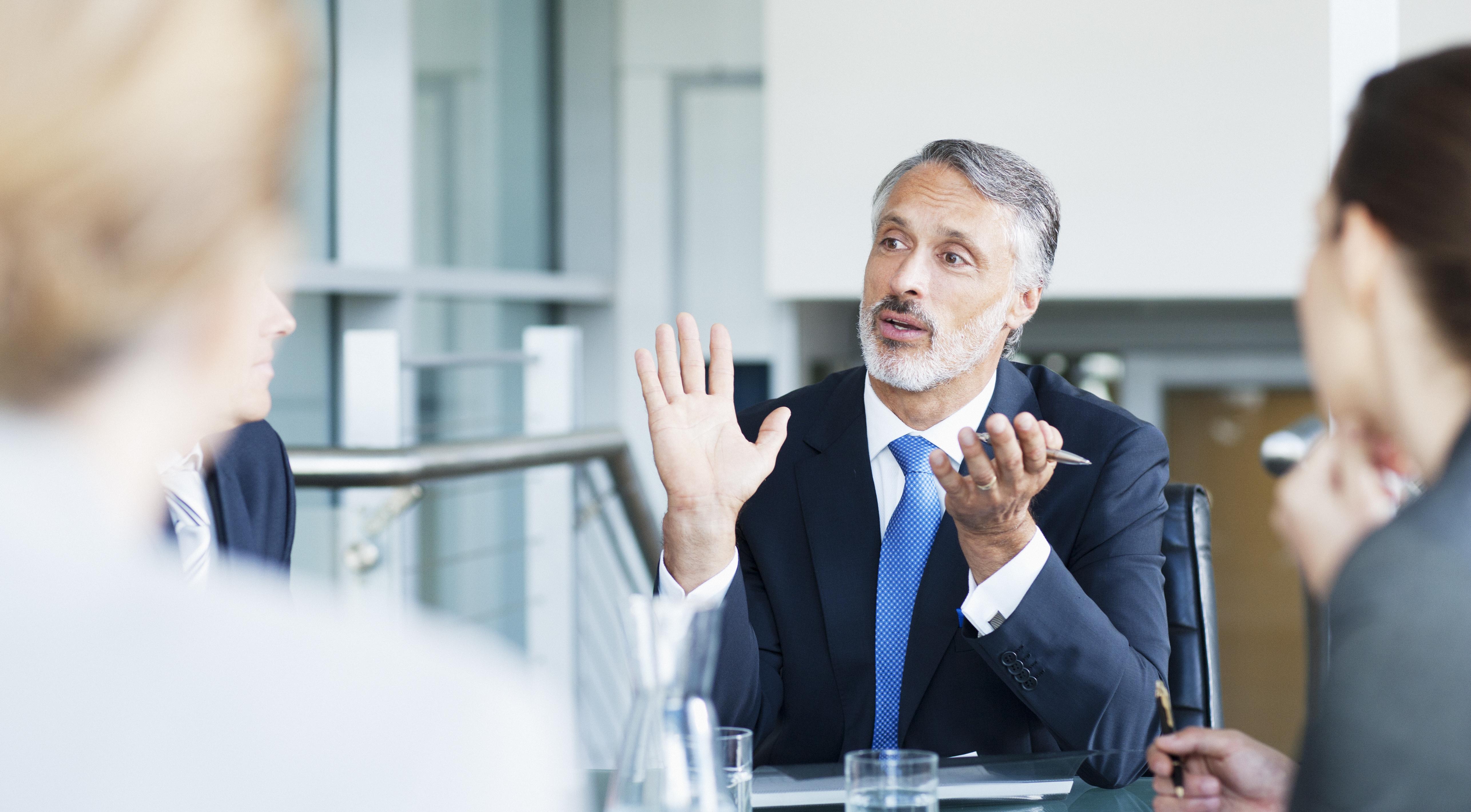 Gesturing businessman leading meeting in conference room