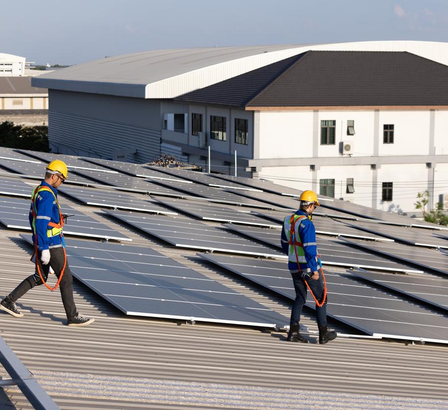 Two engineer walking on rooftop for checking solar panel