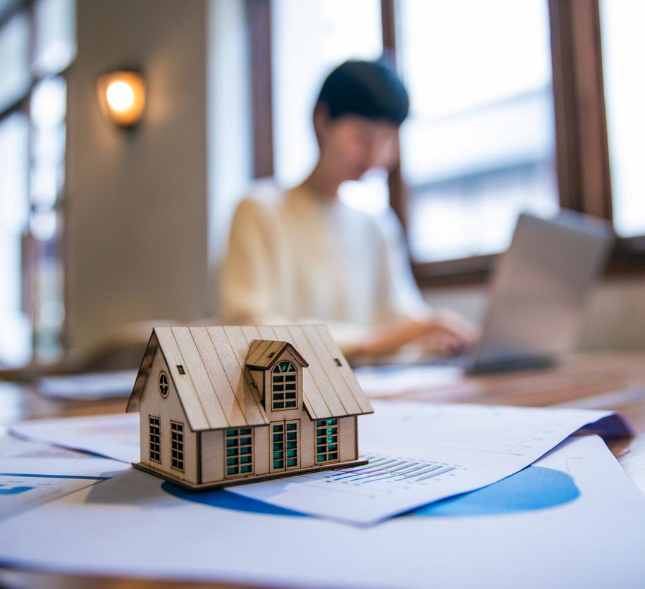 Woman working on taxes behind toy house