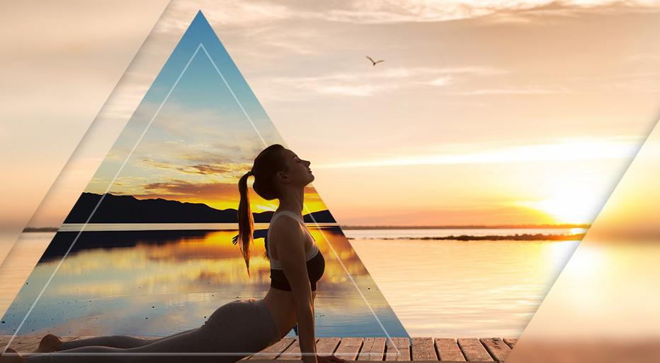 femme en pose de yoga surplombant un lac au lever du soleil.
