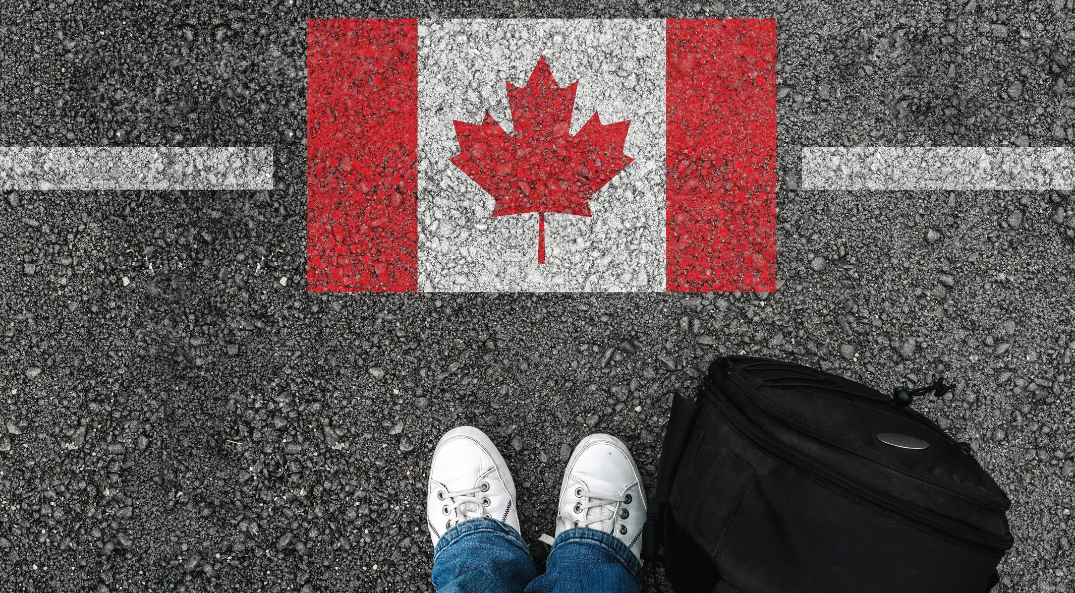 standing next to flag of Canada