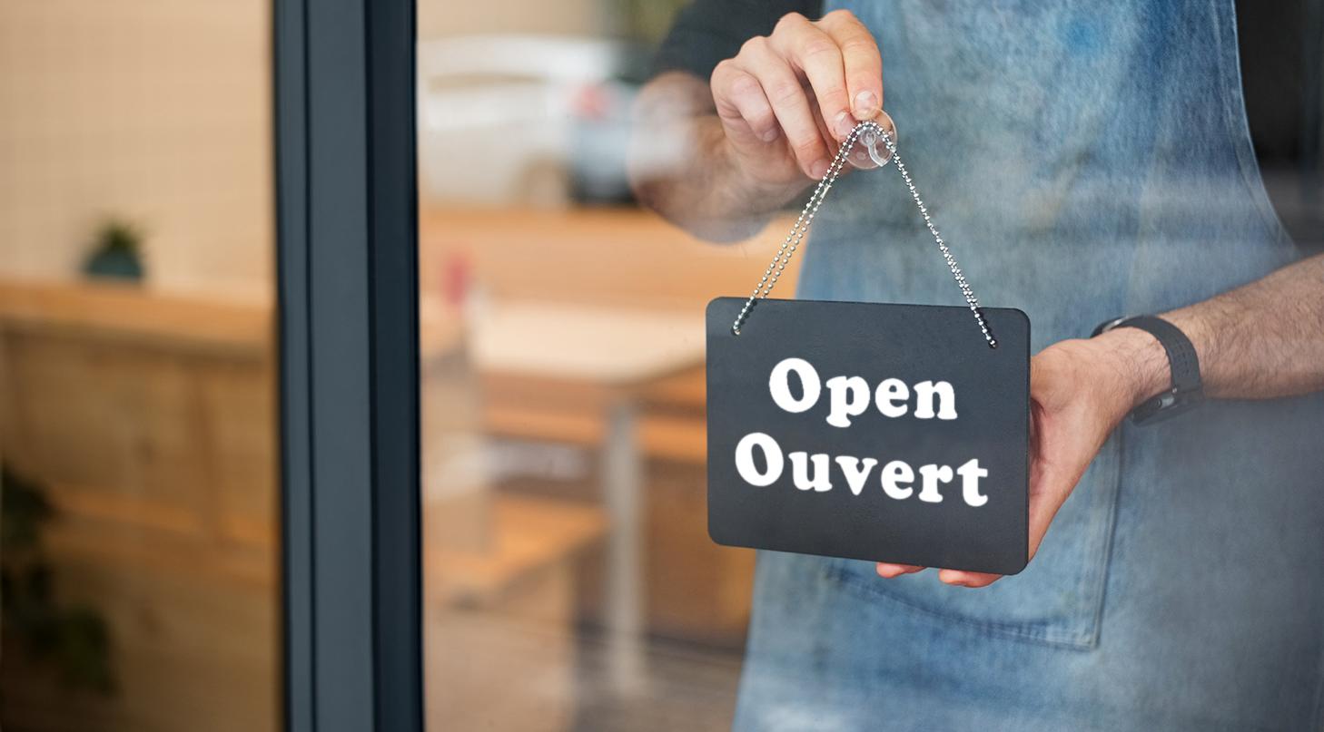 Business owner putting open sign in store